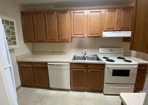 Kings Court Apartments - Front House - Kitchen / Electric range / Range Hood / Dishwasher / Refrigerator / wood-grain cabinets / vinyl flooring