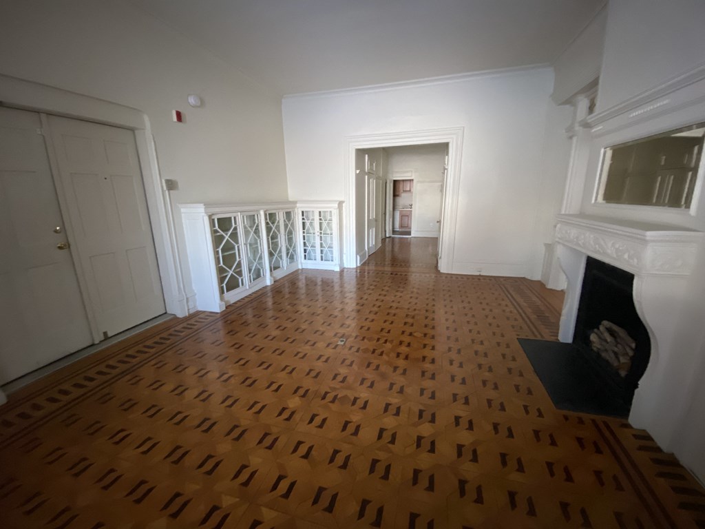 Kings Court Apartments - Front House - Living room / Wood Parquet flooring / Fireplace with Mantel / Built-in, glass-front cabinets / Doors to building entry foyer