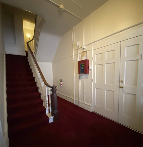 Kings Court Apartments - Front House entry Foyer / Carpeted stairway to upper floor apartments / Doors to Apartment #1