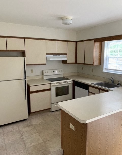 a kitchen with a stove and a refrigerator and a sink