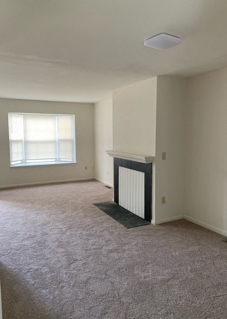 an empty living room with a fireplace and a window