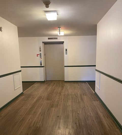 Kings Court Apartments - Main Building - Entry hall to elevators / Wood-grain, vinyl plank flooring