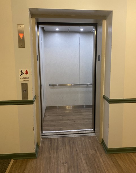 Kings Court Apartments - Main Building - Elevator Interior / Wood-grain, vinyl plank flooring