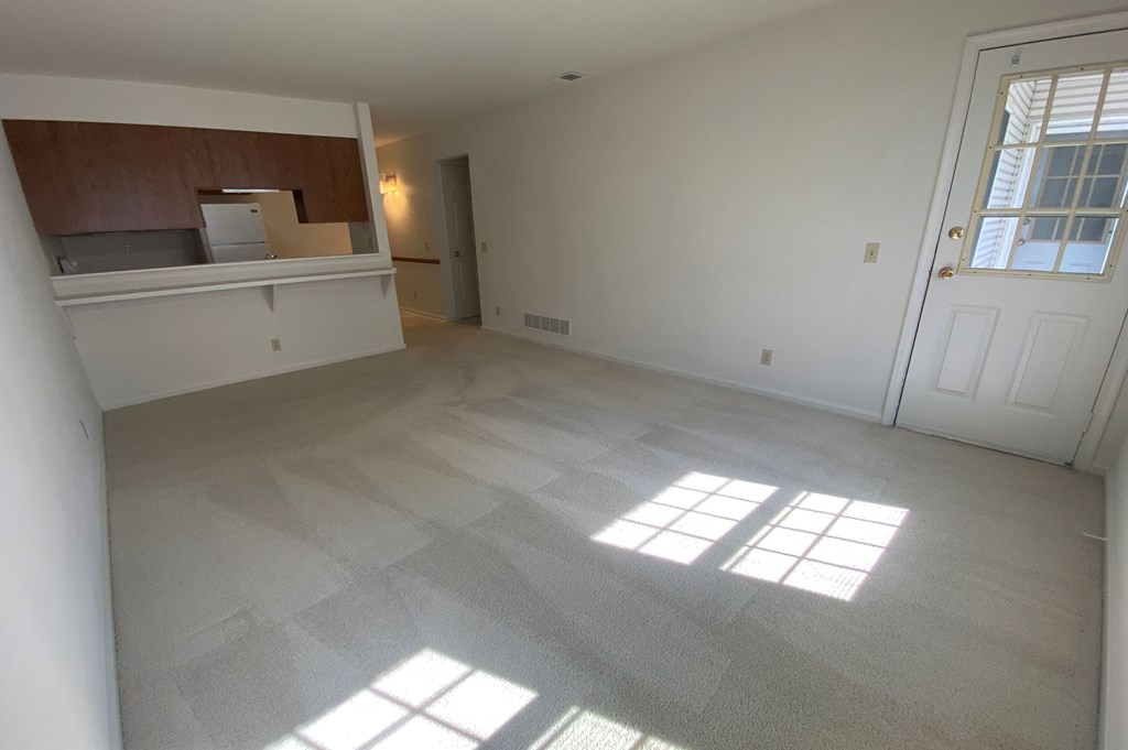 Kings Court Apartments - Main Building - Living room / Pass-thru to kitchen / Door to balcony / Wall-to-wall carpet