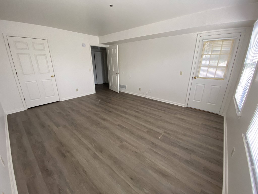 Kings Court Apartments - Main Building - Master bedroom / Wood-grain, vinyl plank flooring / Door to balcony/patio.