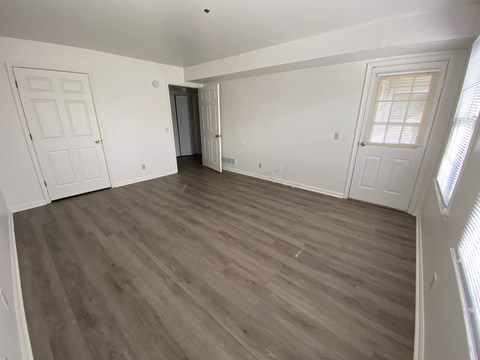 Kings Court Apartments - Main Building - Master bedroom / Wood-grain, vinyl plank flooring / Door to balcony/patio.