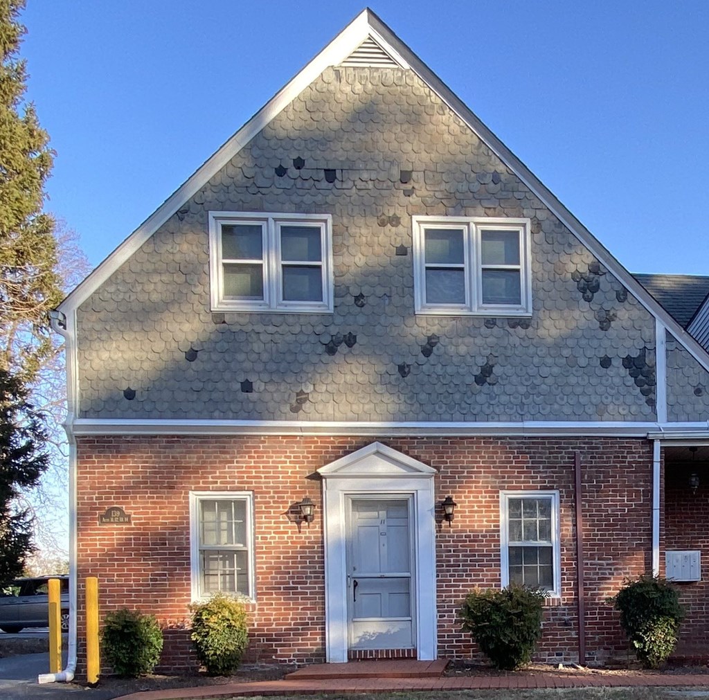 the front of a brick house with a white door
