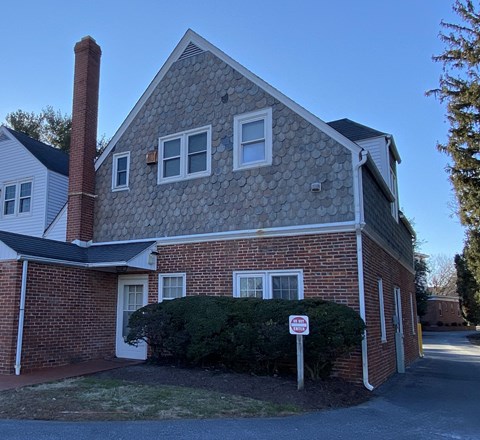 the front of a brick house with a no parking sign