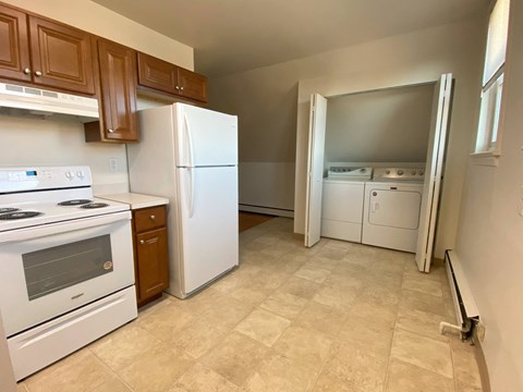 a kitchen with white appliances and wooden cabinets
