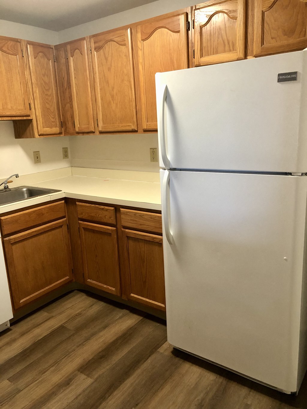 Loockerman Square Apartments - Kitchen with Refrigerator / Wood-grain cabinets / Wood-grain vinyl plank flooring