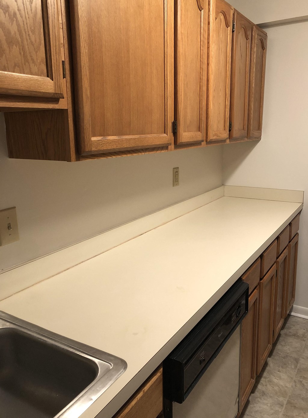 Loockerman Square Apartments - Kitchen with wood-grain upper & lower cabinets.