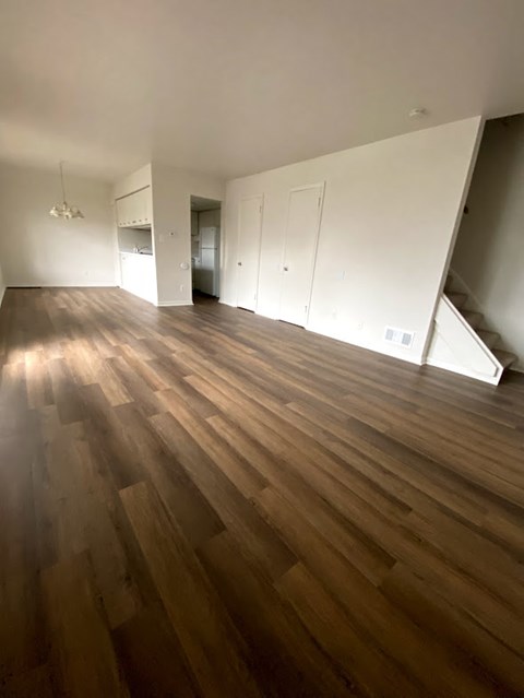 an empty living room with white walls and wooden floors