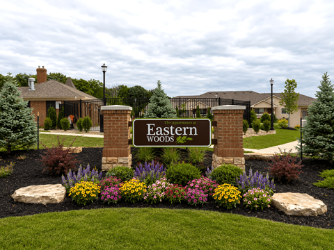 A sign that says "Eastern Woods" in front of a house.