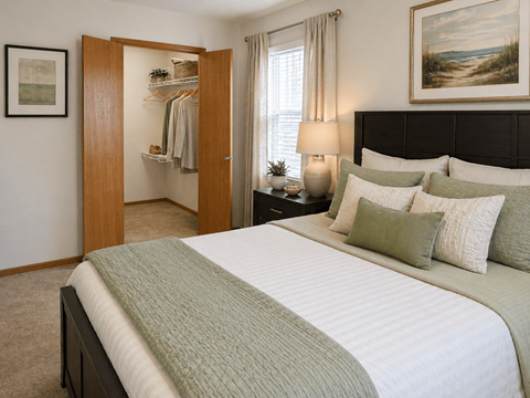 A bedroom with a large bed and a painting on the wall.