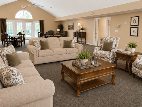 A living room with a variety of furniture including a couch, armchair, and coffee table.