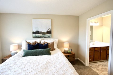 A bedroom with a large bed and a painting on the wall.