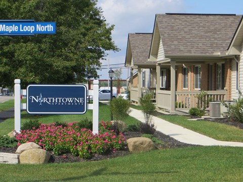 A sign for Northtown Estates is in front of a house.