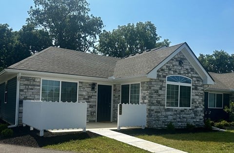 a stone house with two white fences in front of it