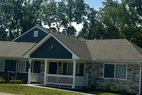 a house with a gray roof and a white porch