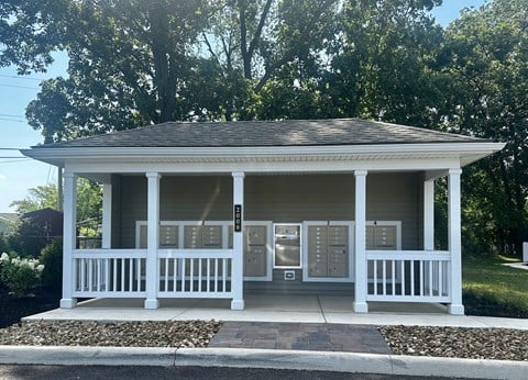 a white gazebo with a porch and some trees