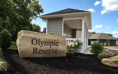 A house with a sign that says Olympic Reserve in front of it.
