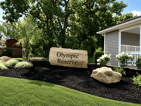 A sign that says "Olympic Reserve" is in front of a house.