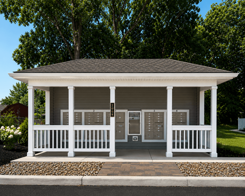 A mailbox area with roof and white railing.