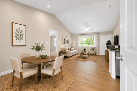 A dining room with a round table and chairs.