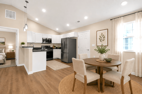 A kitchen with a dining table and chairs.