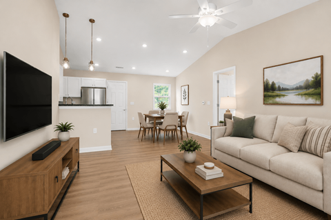 A living room with a couch, a coffee table, and a television.