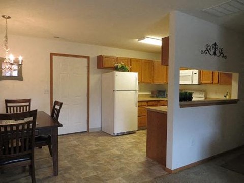 A kitchen with a table and chairs in it.