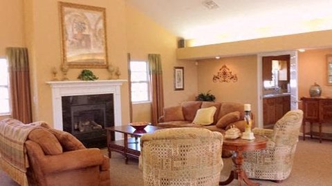 A living room with a fireplace and a painting on the wall.