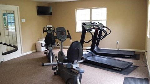 A home gym with a treadmill, elliptical trainer and a stationary bike.