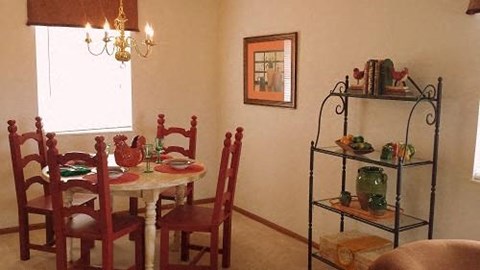 A dining room with a table set for four.