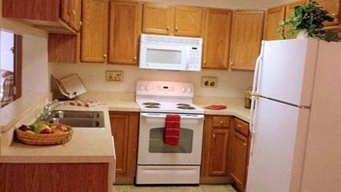 A kitchen with wooden cabinets and a white refrigerator.
