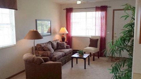 A living room with a couch, chair, and lamp.