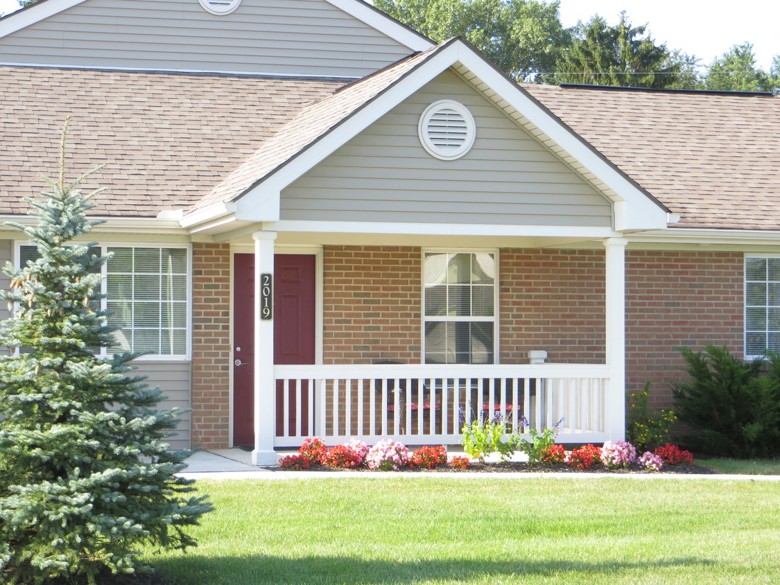 a home with a porch and a red door