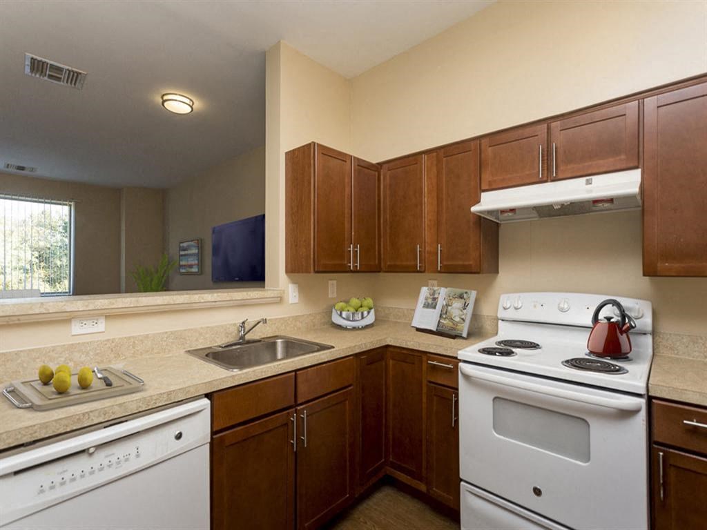 a kitchen with white appliances and wooden cabinets