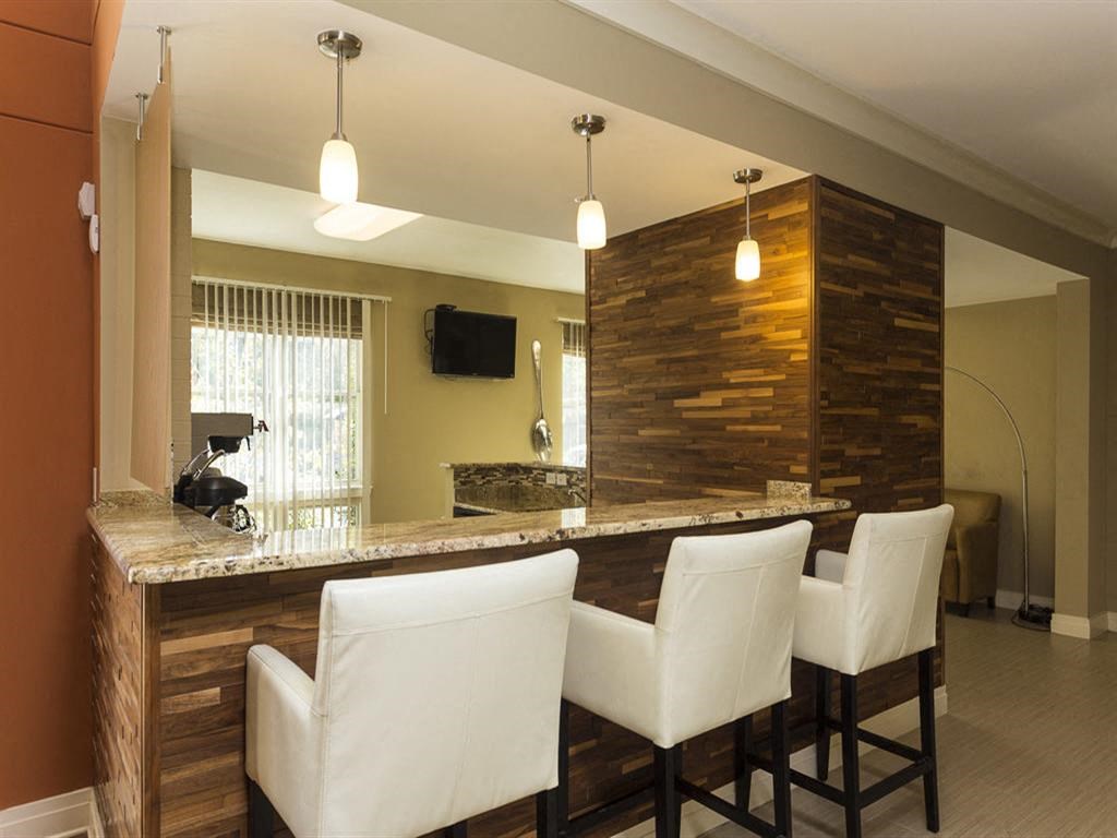 a bar in a living room with white chairs