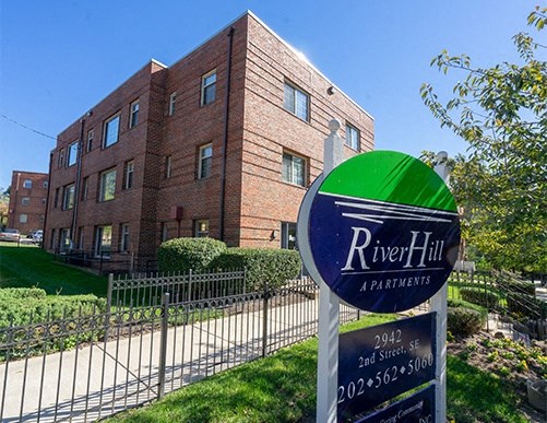 an apartment building with a river hill apartments sign in front
