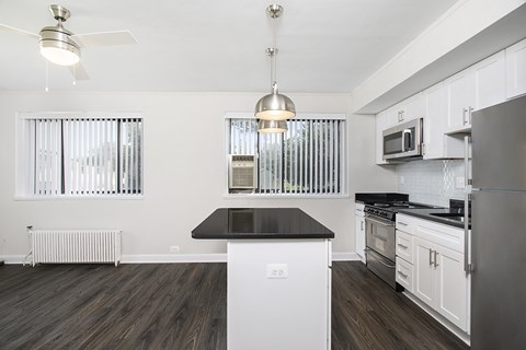 A modern kitchen with white cabinets and a black island.