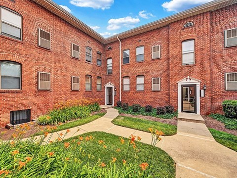 A red brick building with a walkway in front.