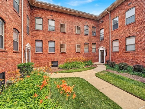 A red brick building with a white door and windows.