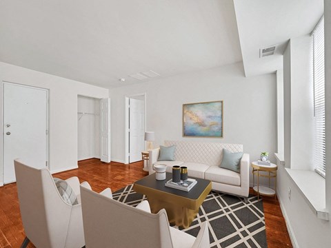 A living room with a white couch, a coffee table, and a painting on the wall.