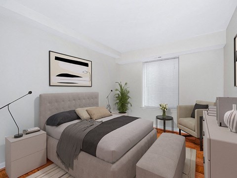 A bedroom with a large bed and a chair.
