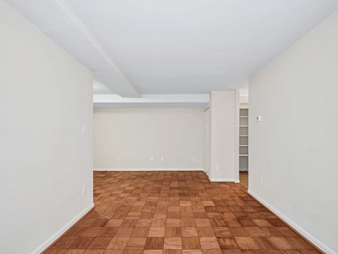 A room with wooden flooring and white walls.