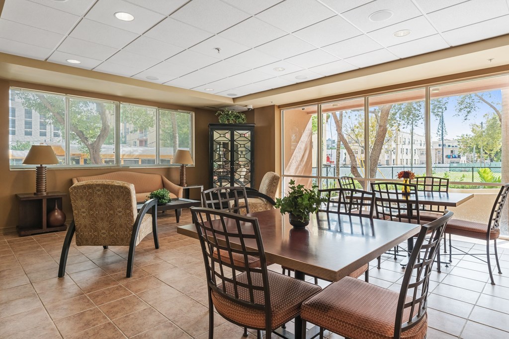 a dining room with tables and chairs and large windows