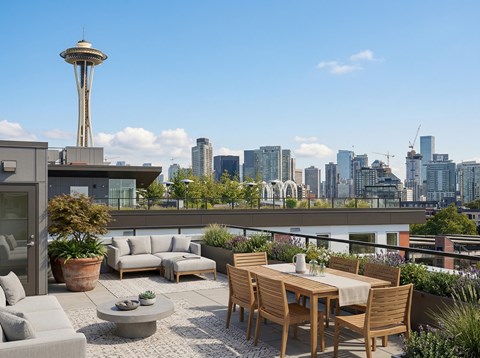 Rooftop deck with dining table, lounge seating, and view of the Space Needle and Seattle skyline.