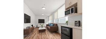 A modern kitchen with a refrigerator, microwave, and oven.