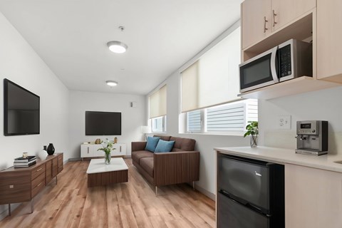 A modern kitchen with a refrigerator, microwave, and oven.